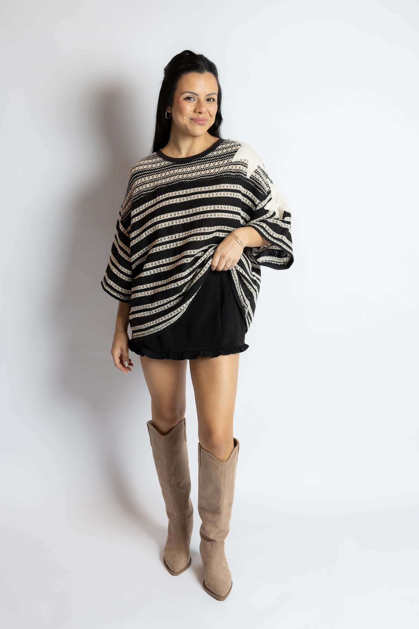 Woman wearing a black and white striped sweater with a plain background