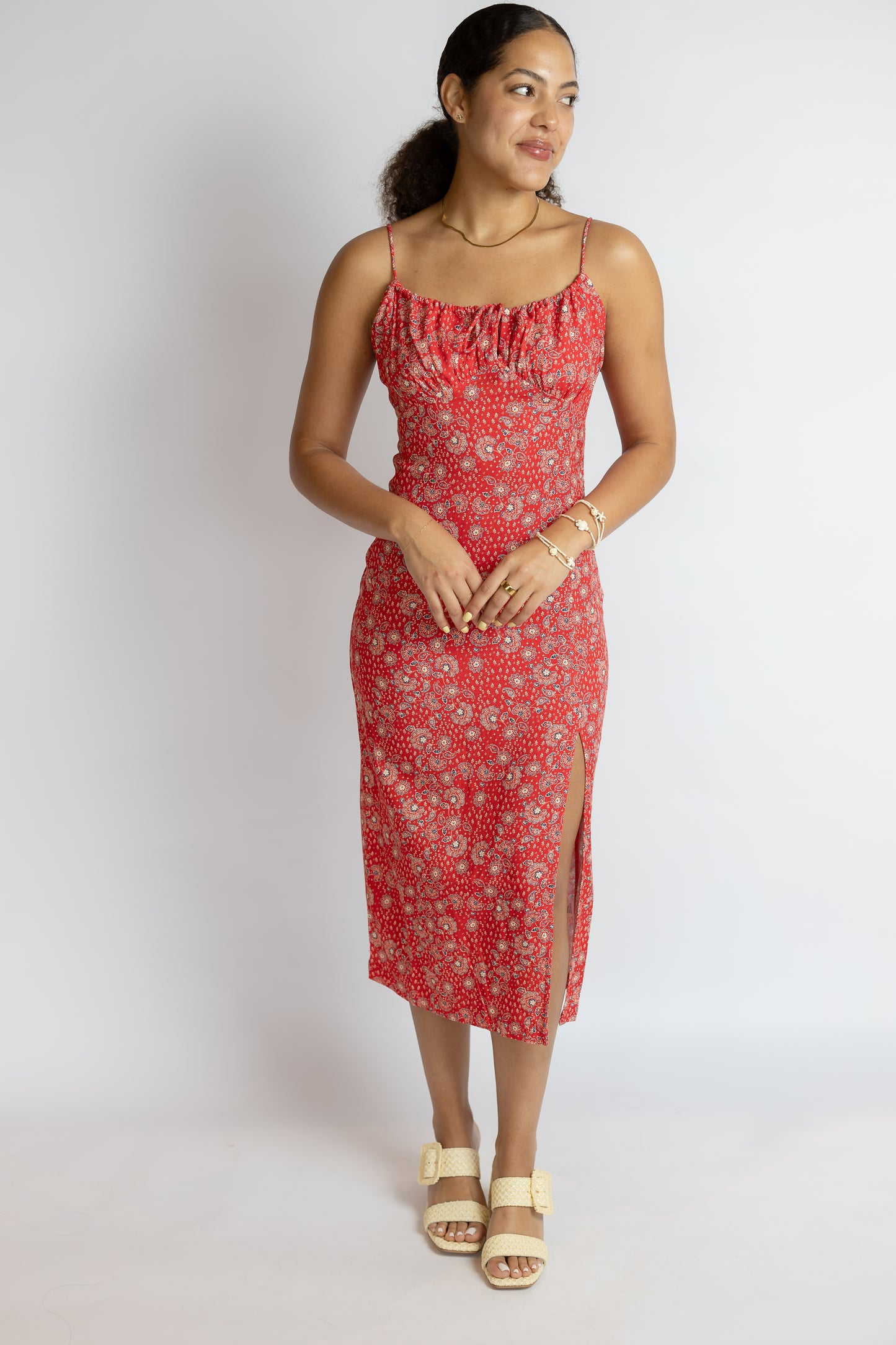 Woman wearing a red bandana paisley print dress on a white background