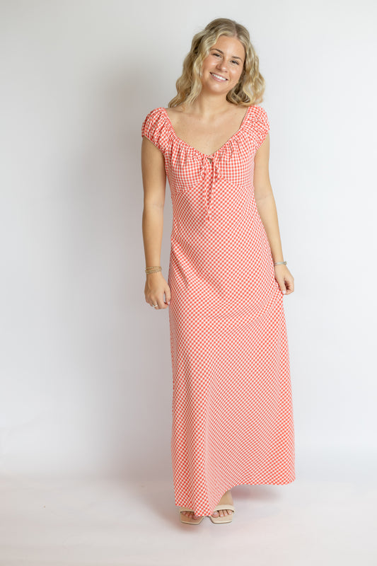 Woman wearing a red and white checkered dress on a white background