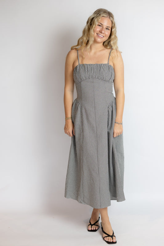 Woman wearing a black and white gingham dress against a white background