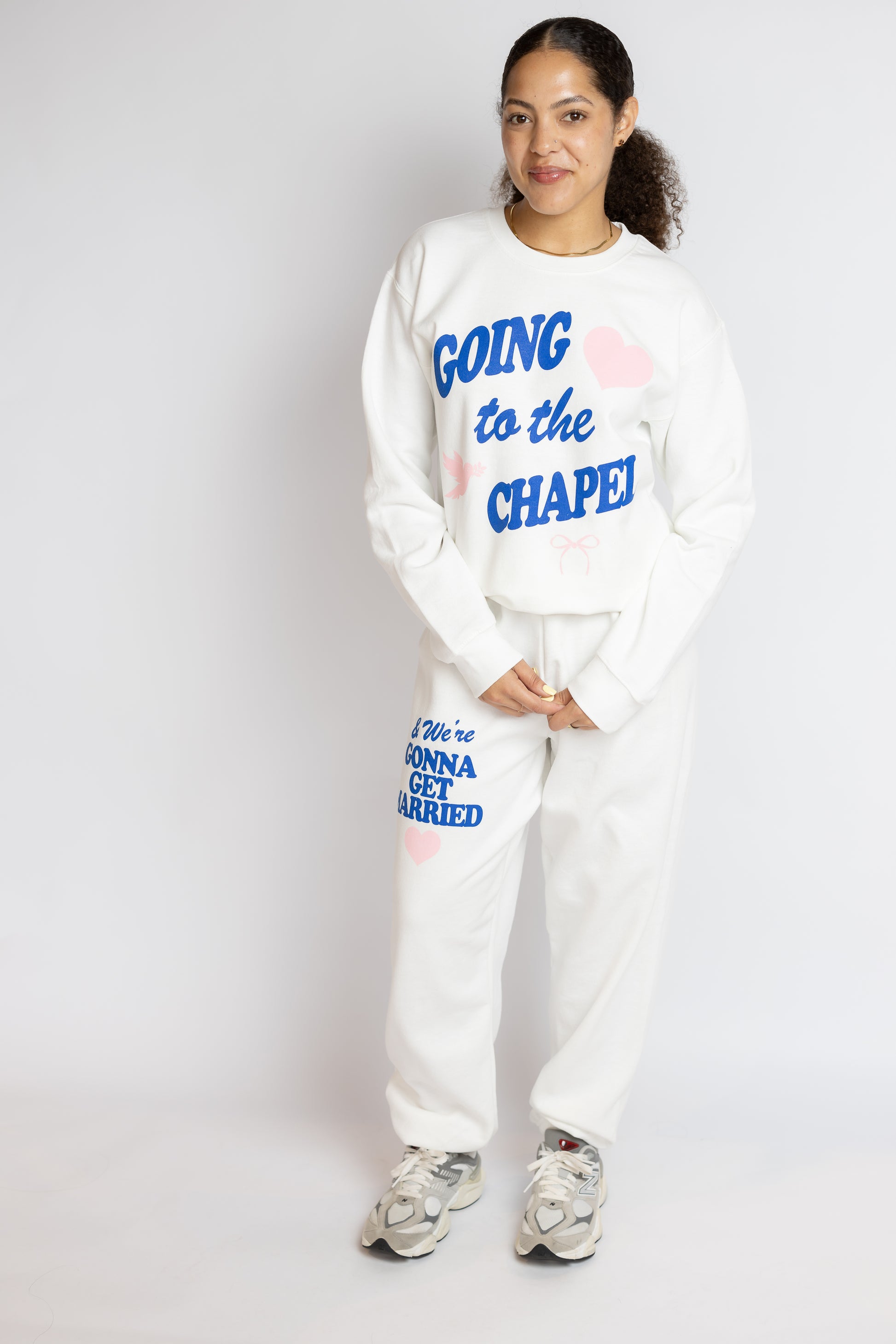 Person wearing a white sweatshirt and pants with Gonna Get Married text, standing against a plain background