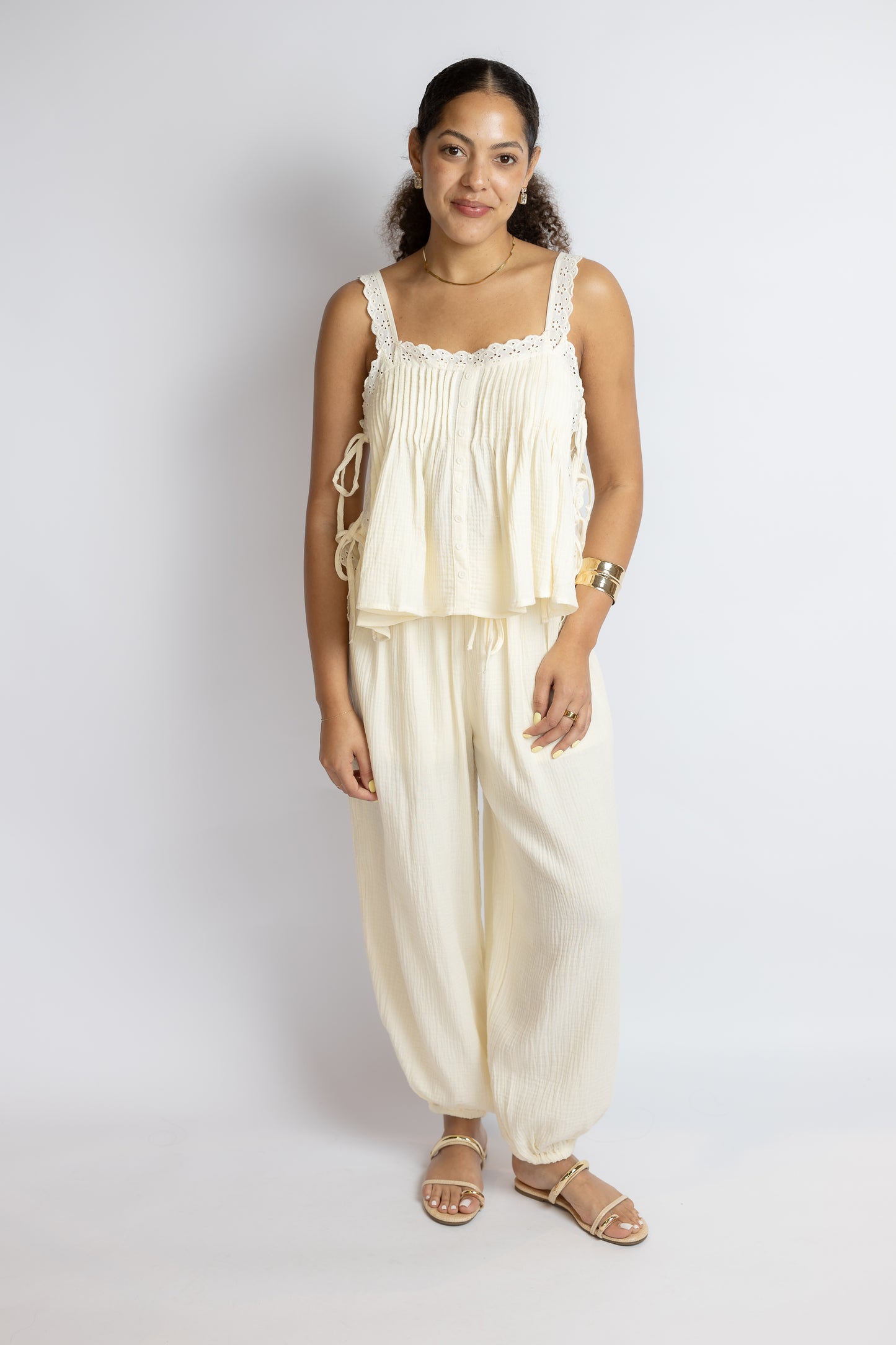 Woman wearing a cream-colored outfit against a white background