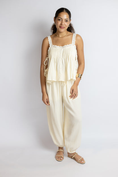 Woman wearing a cream-colored outfit against a white background
