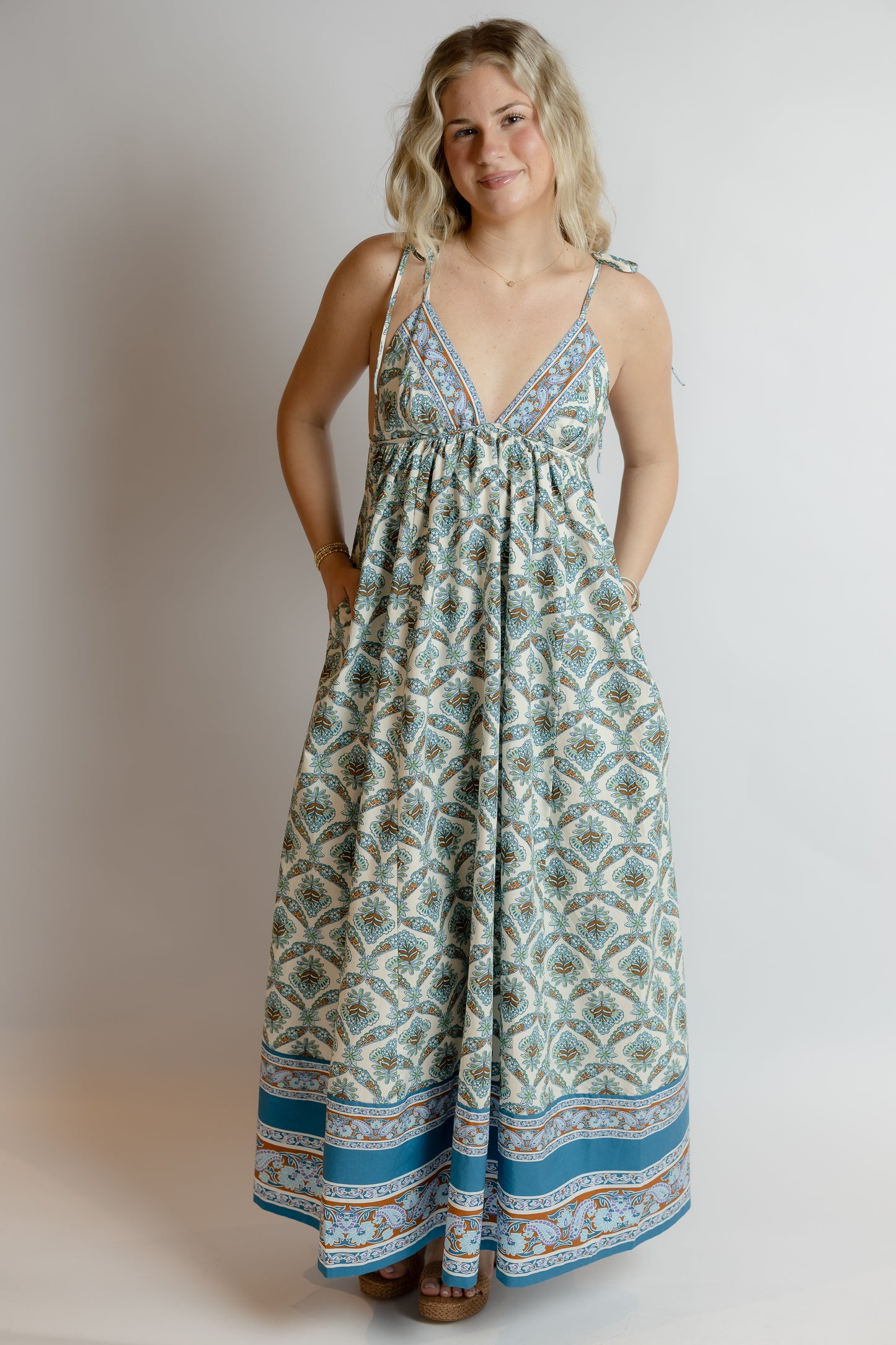 Woman wearing a patterned dress against a plain background