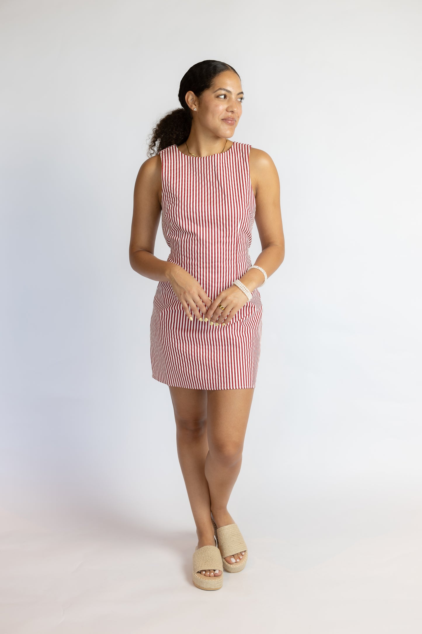 Woman wearing a red and white striped dress on a white background