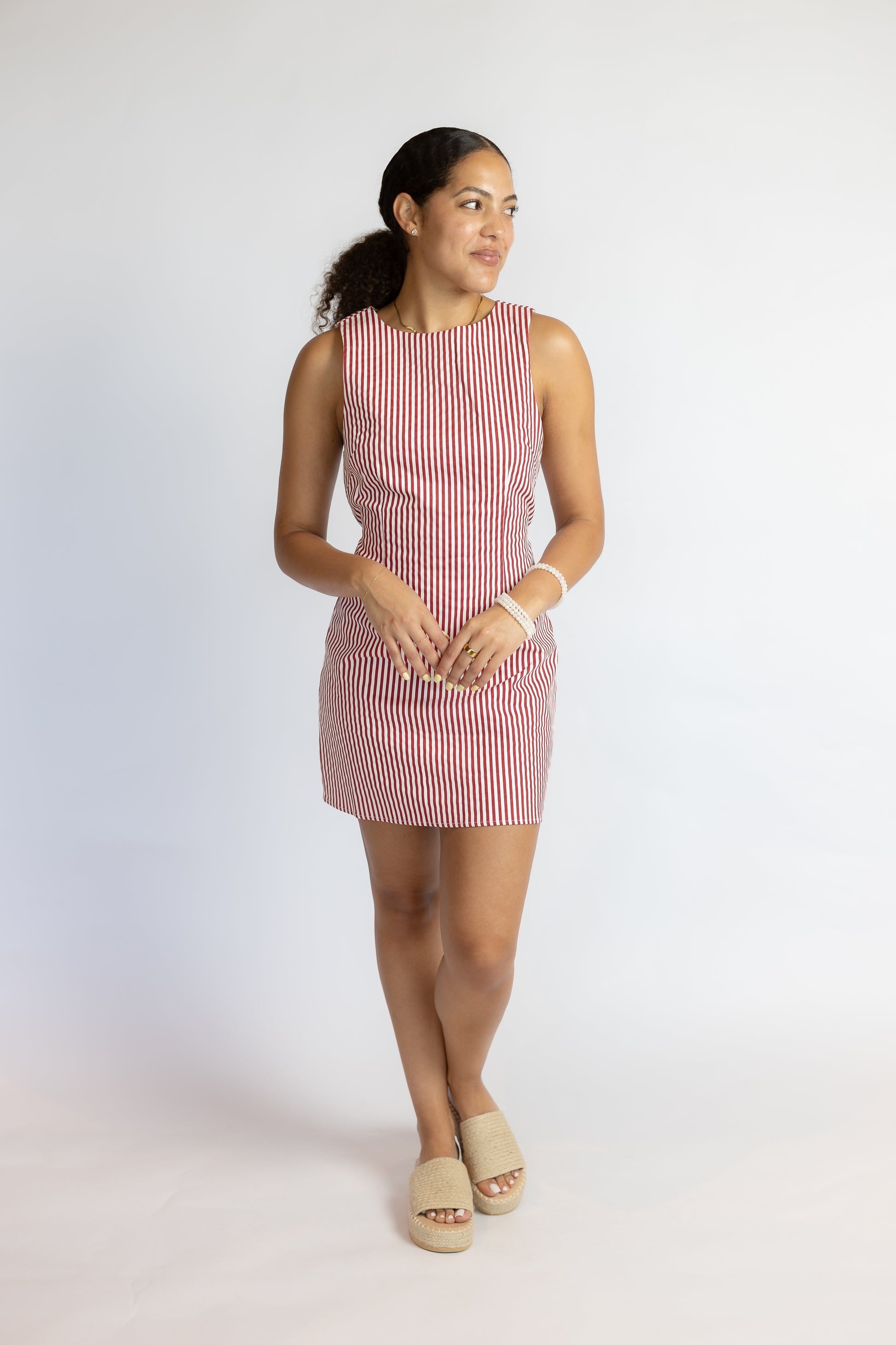 Woman wearing a red and white striped dress on a white background