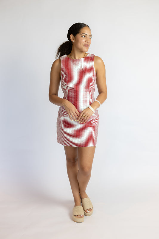 Woman wearing a red and white striped dress on a white background