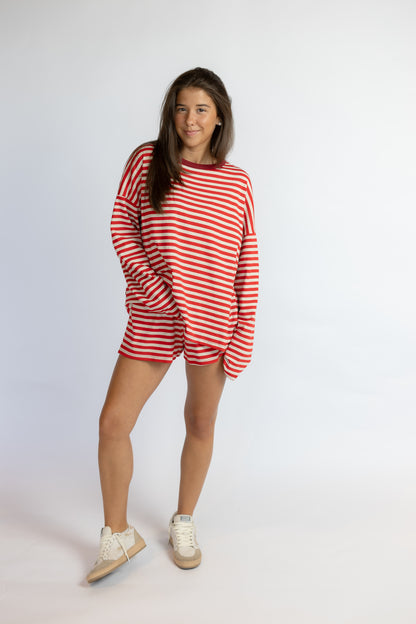 Person wearing a red and white striped outfit on a plain background