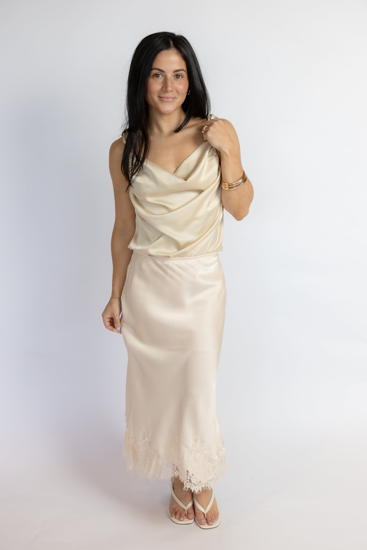 Woman wearing a beige evening gown against a white background