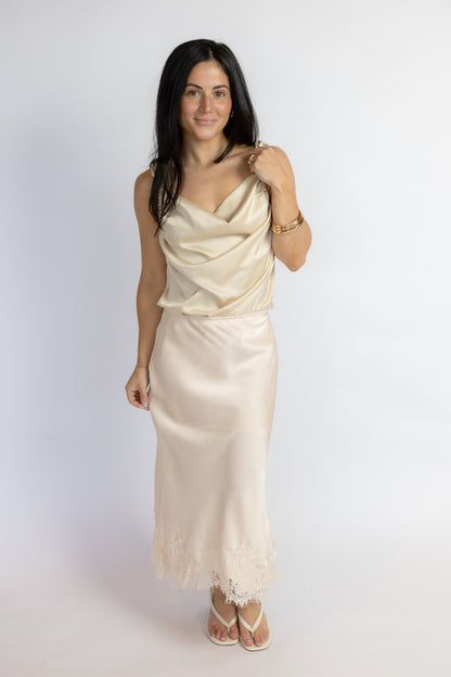 Woman wearing a beige evening gown against a white background
