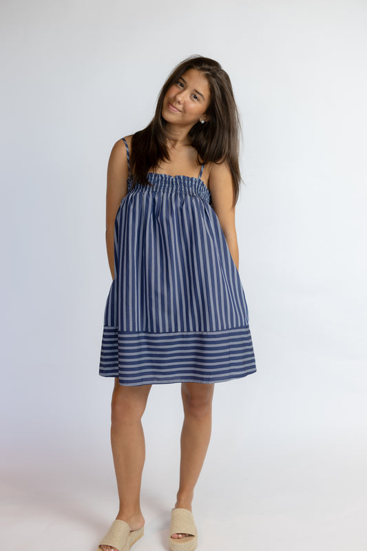 Woman wearing a blue striped dress on a white background