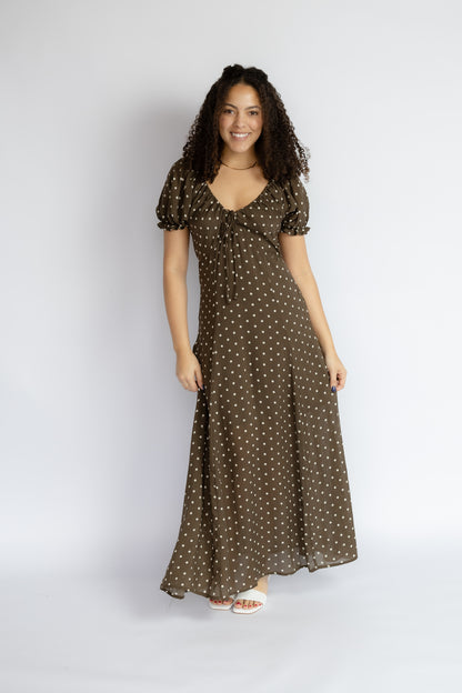 Woman wearing a brown polka dot dress on a white background