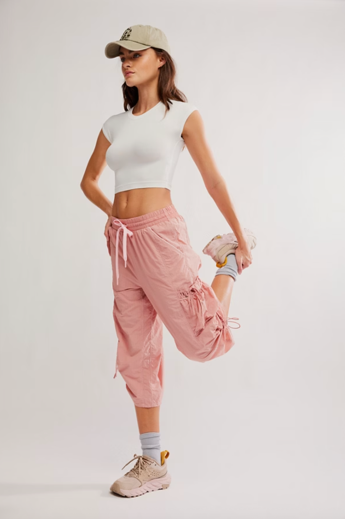 Model wearing the Never Better Ultra-Light Tee in white, styled with pink jogger pants and sneakers.