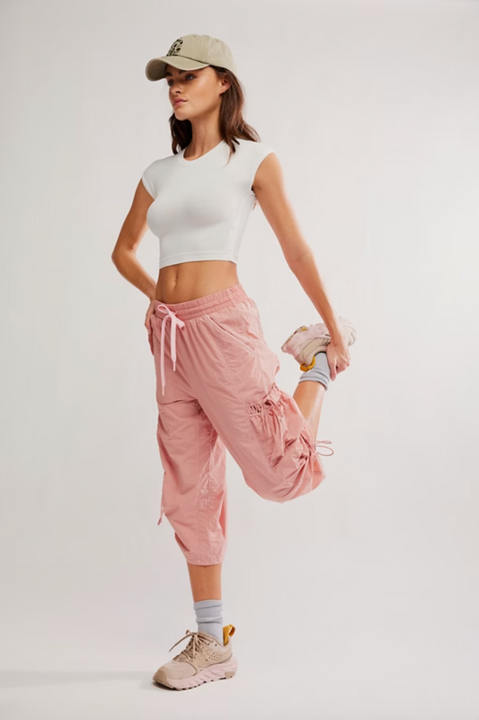 Model wearing the Never Better Ultra-Light Tee in white, styled with pink jogger pants and sneakers.