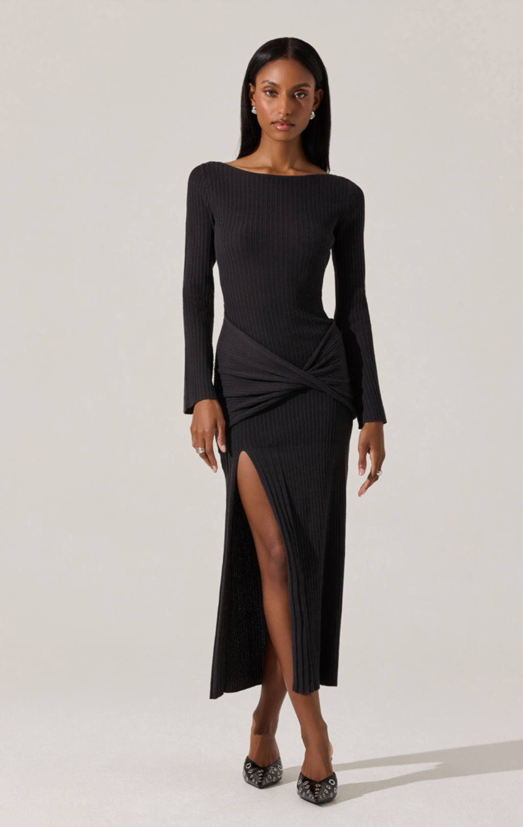 Model wearing the Arywn Wrap Detail Long Sleeve Sweater Dress in black with wrap waist detail, boatneck, and side slit