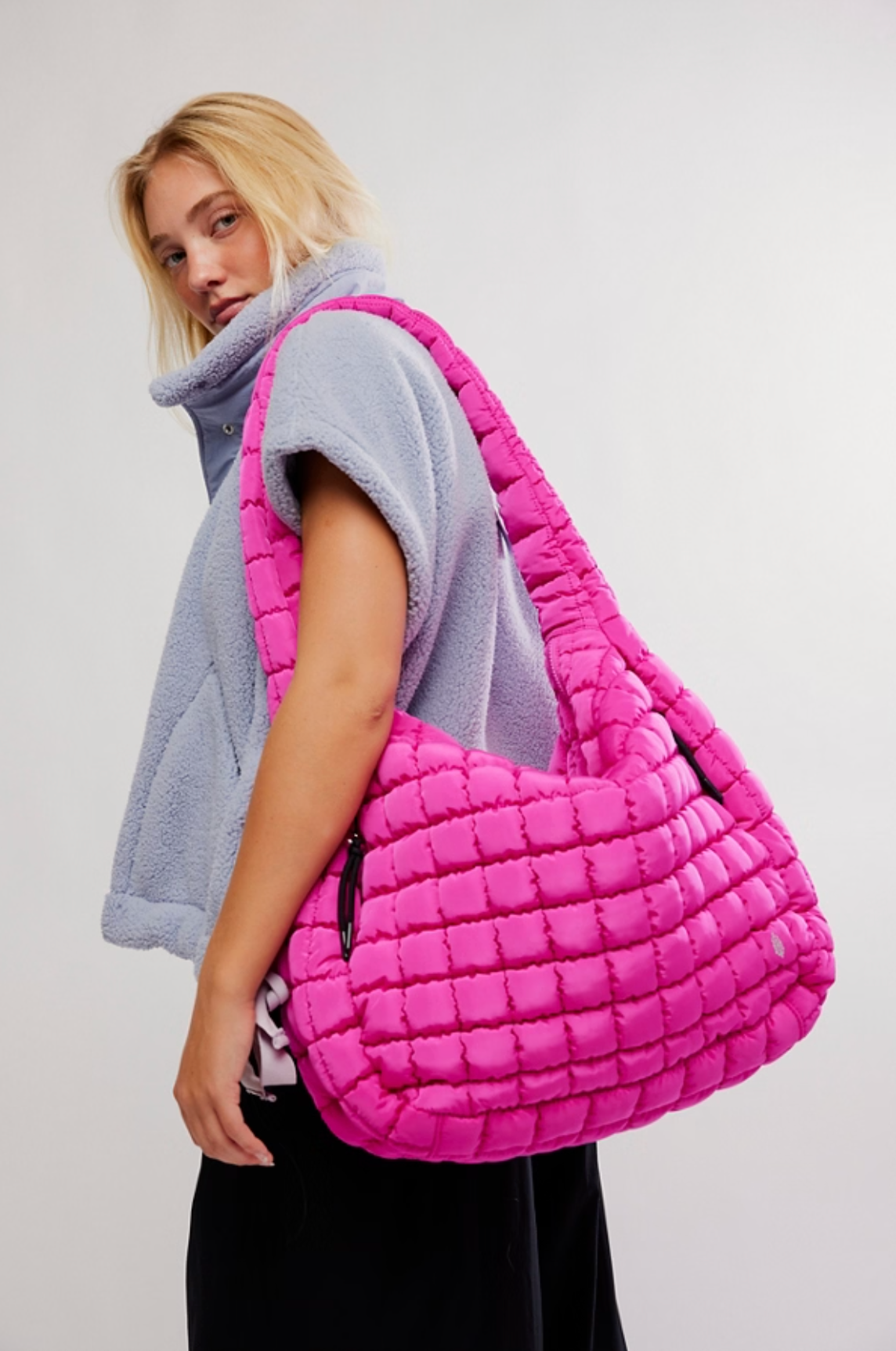 Fuchsia pink quilted oversized carryall bag with shoulder strap and zip closure