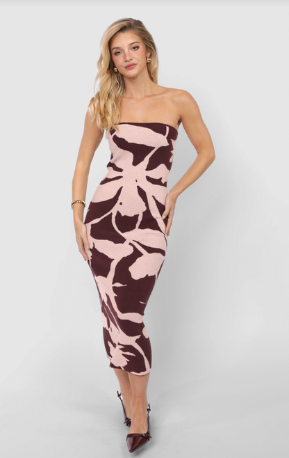 Model wearing strapless knit jacquard tube dress in blush and burgundy abstract print