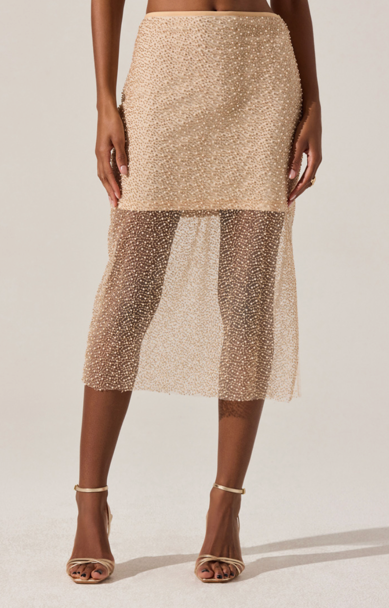 Model wearing the Messina Skirt, a shimmering beaded mesh midi skirt with sheer hem and side slit.