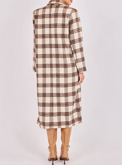 Person wearing a long plaid coat on a plain background