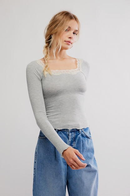 Woman wearing gray lace trim long sleeve micro rib top with lettuce edge hem