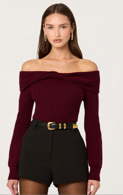 Woman wearing burgundy off-the-shoulder ribbed knit sweater with foldover neckline and long sleeves.