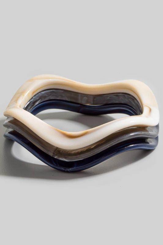 Three-piece wavy resin bracelet set in ivory, smoke, and navy stacked together