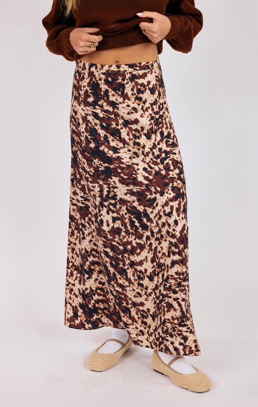 woman wearing brown and cream printed maxi skirt with bias-cut drape and cozy knit sweater
