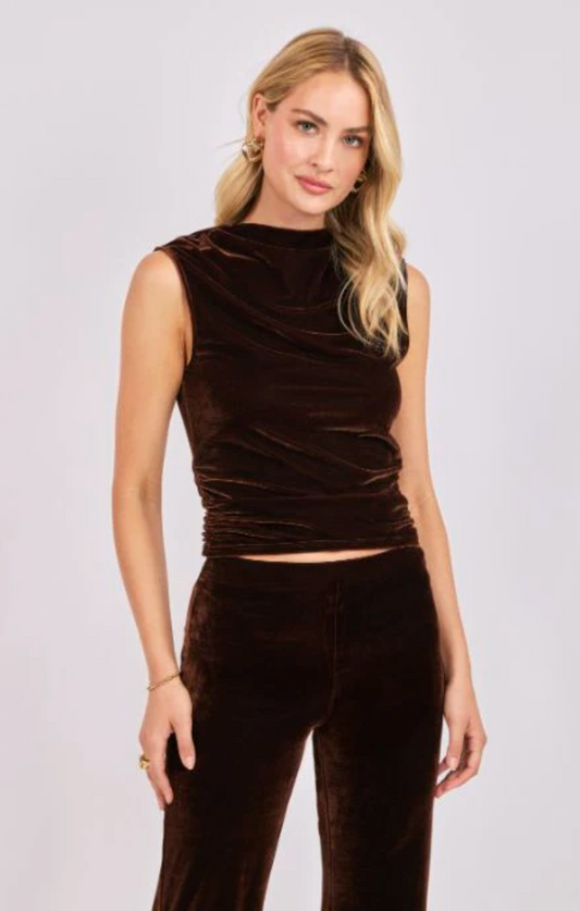 woman wearing brown sleeveless velvet top with high ruched neckline and matching velvet pants