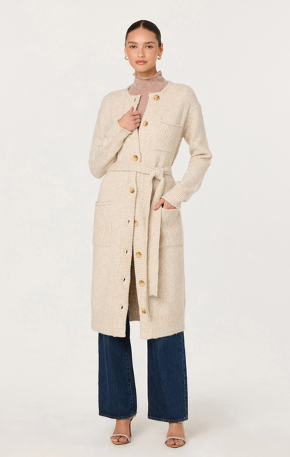 Woman wearing a long beige coat on a white background
