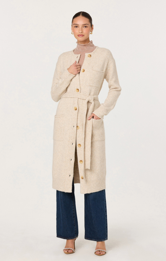 Woman wearing a long beige coat on a white background