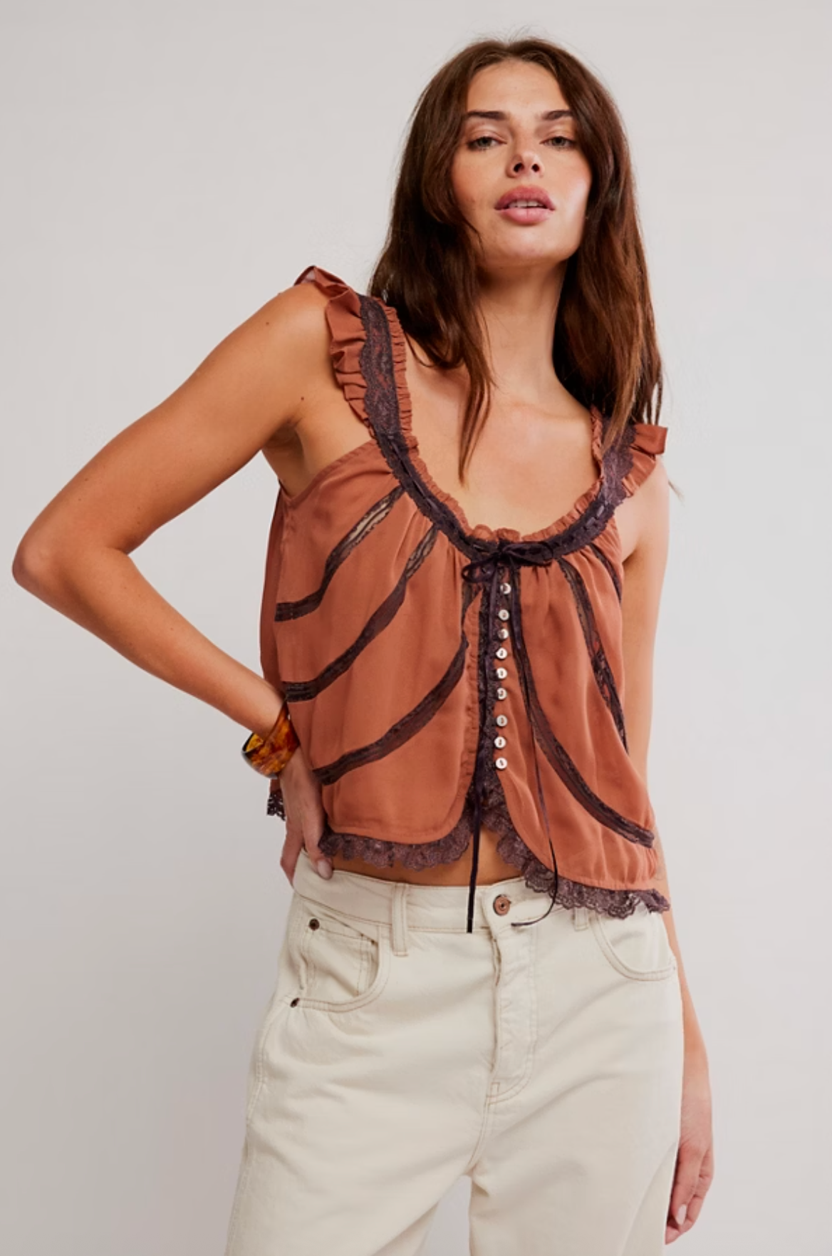 Model wearing a lace-trimmed vintage-inspired button-front tank top with ruffled details