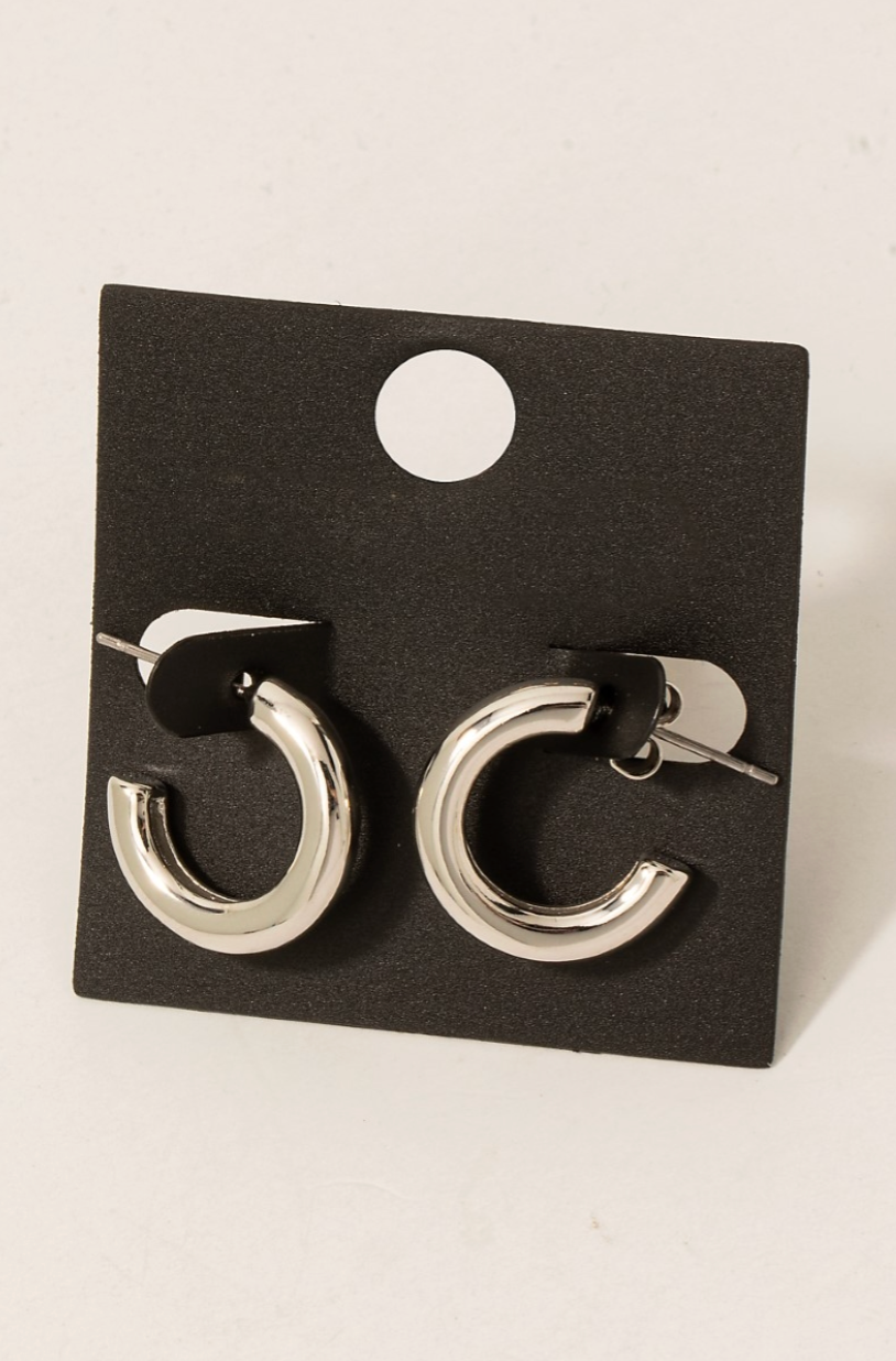 Pair of silver hoop earrings on a black card against a white background
