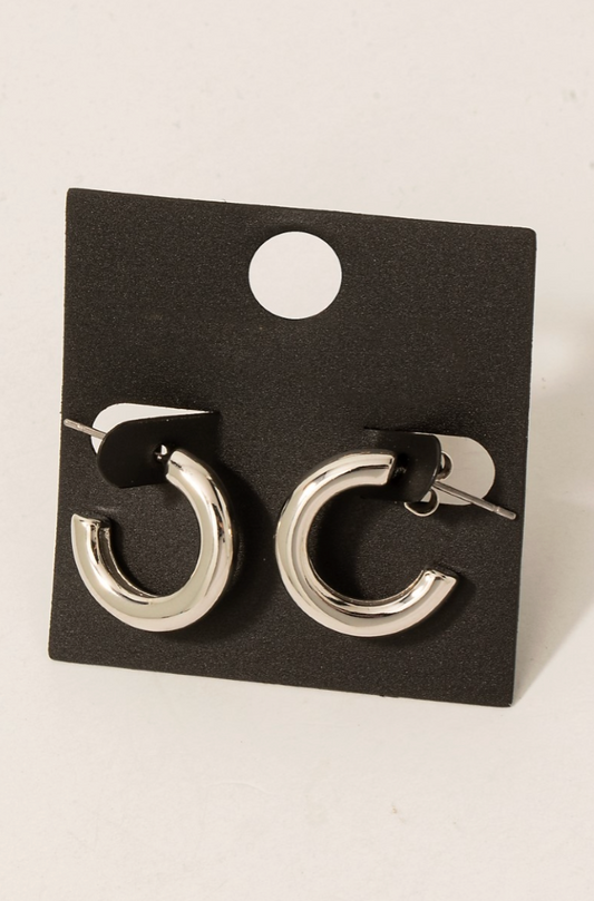 Pair of silver hoop earrings on a black card against a white background
