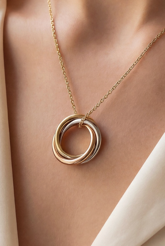 Gold necklace with a double ring pendant on a person's neck