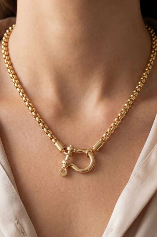 Gold necklace with a clasp on a person's neck