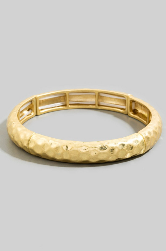 Gold bracelet on a gray background