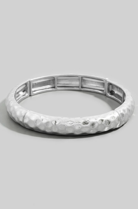 Silver bracelet with a textured band on a light gray background