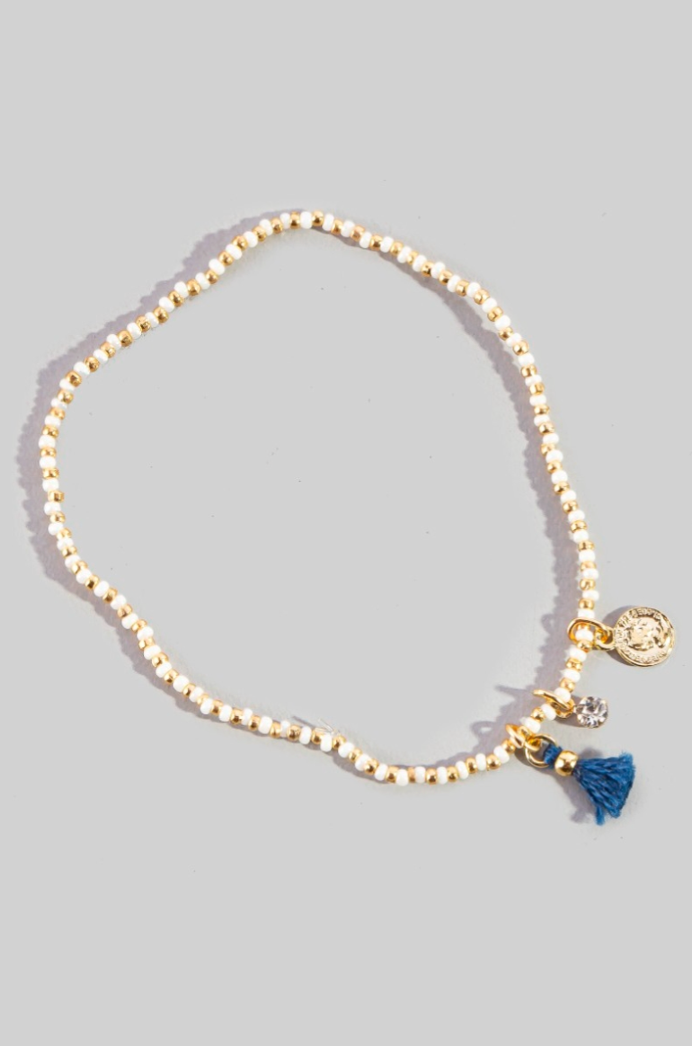 Gold bracelet with charms on a gray background
