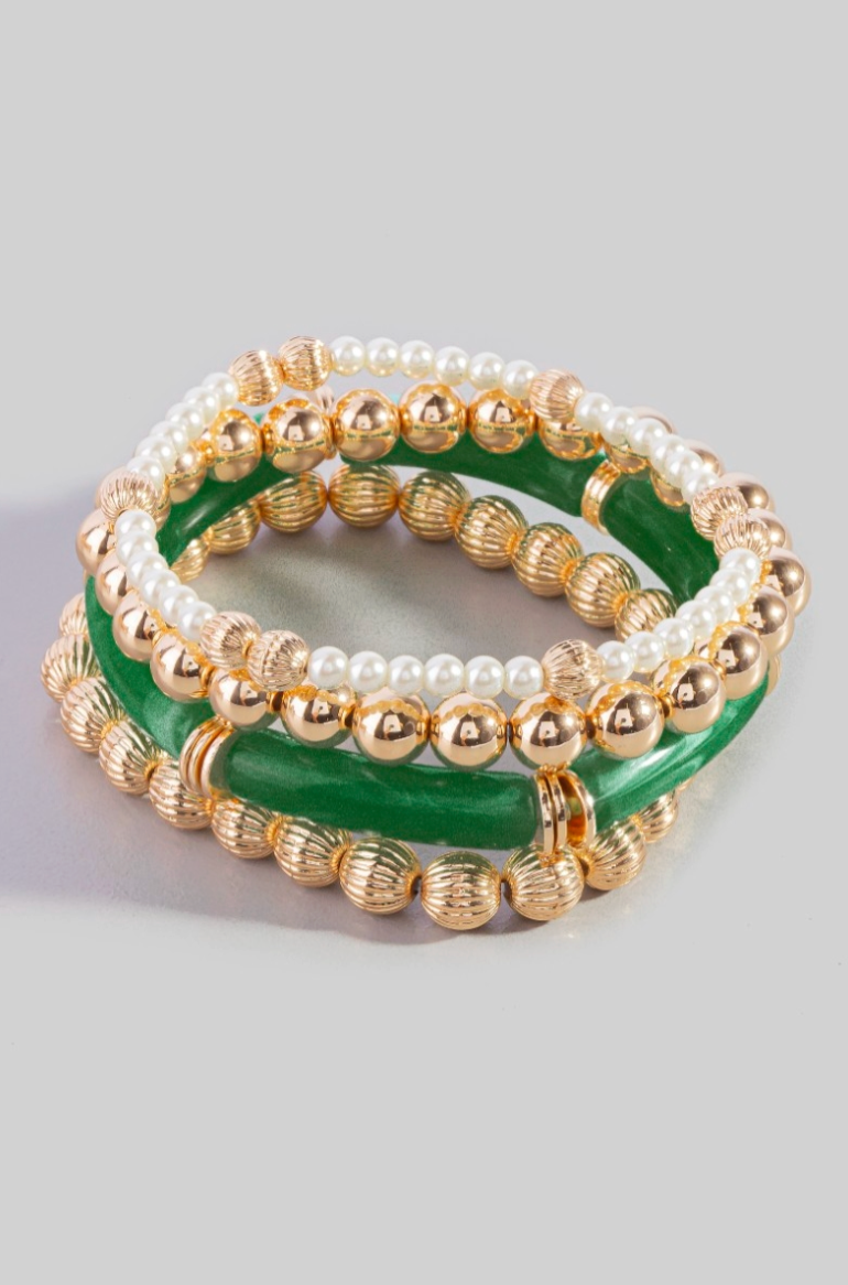 Set of three beaded bracelets with gold and green accents on a light gray background
