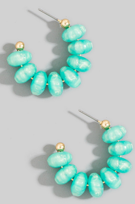 Turquoise beaded earrings with gold accents on a gray background