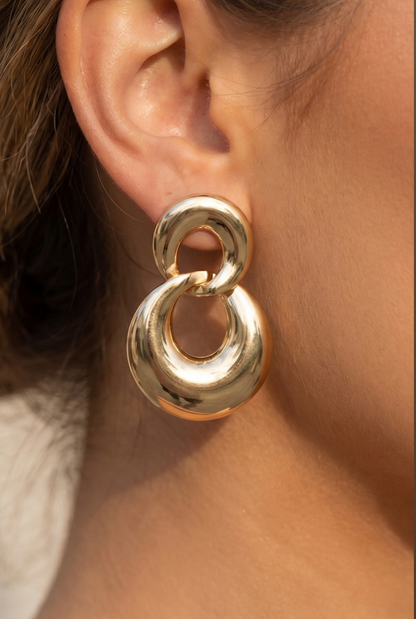 Gold double circle drop earrings with oversized polished interlocking rings.