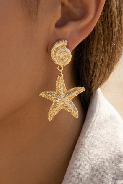 Gold shell and starfish drop earrings with a polished textured finish.