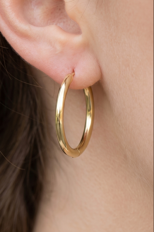 Polished gold tube hoop earrings with a smooth rounded silhouette and secure clip-back closure.