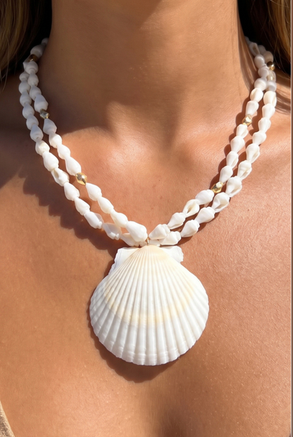 Double-strand natural shell bead necklace with an oversized white scallop shell pendant and gold-tone spacer accents.
