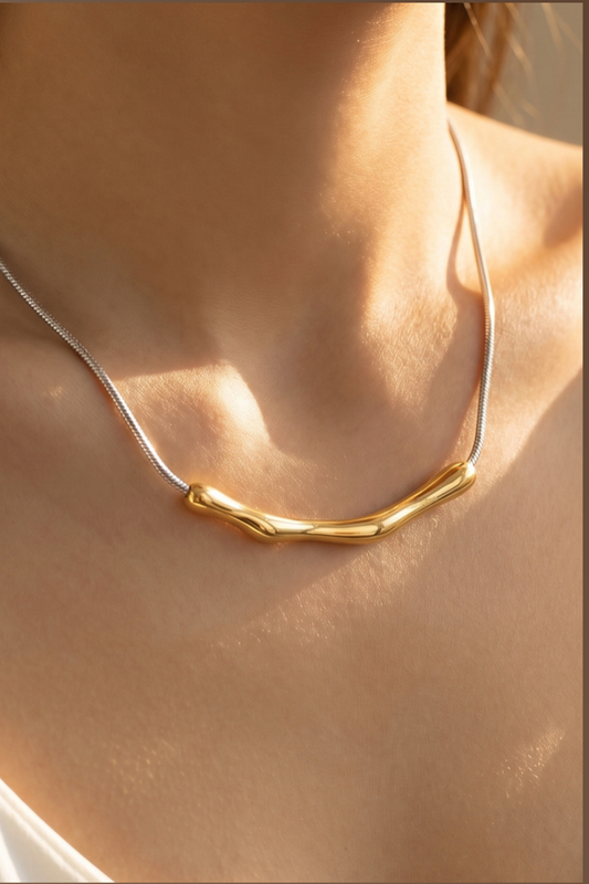 Gold organic bar pendant necklace on a herringbone chain worn on a model.