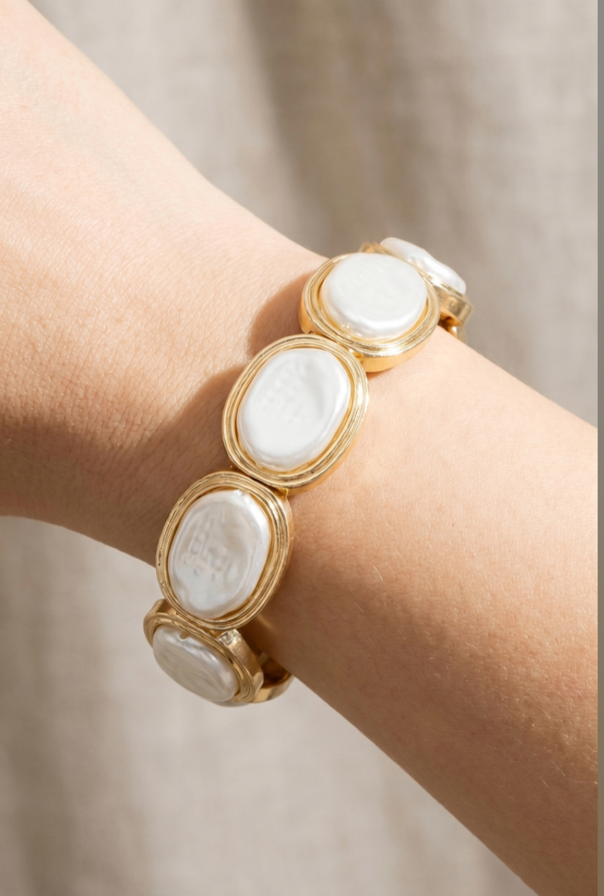 Gold-tone bracelet with oval pearl-finish resin stones in polished bezel settings.