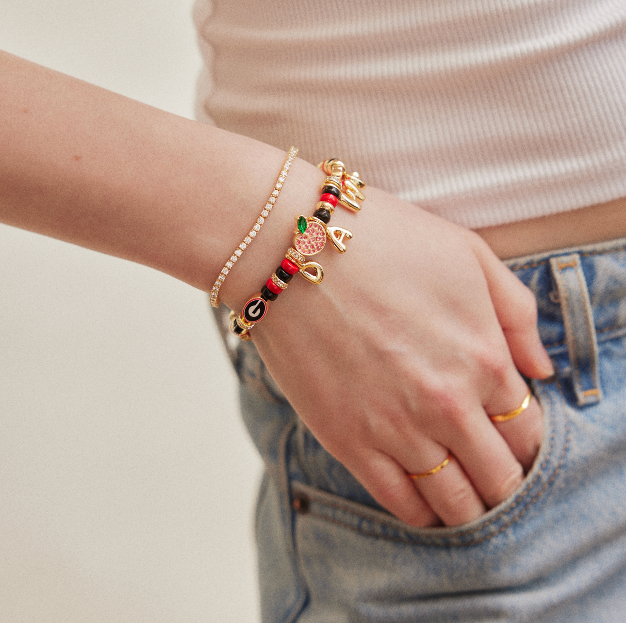 University of Georgia beaded stretch bracelet with red, black, and gold beads featuring Bulldog mascot, Georgia "G," football helmet, jersey, peach, and DAWGS letter charms.