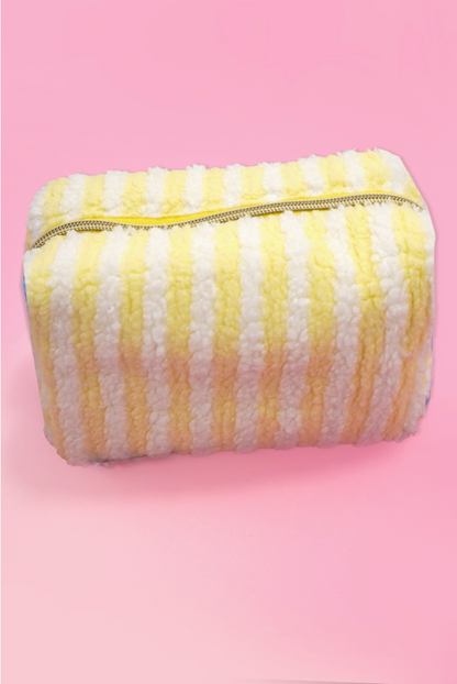 Yellow and white striped sherpa makeup pouch with gold zipper and plush teddy fleece fabric.