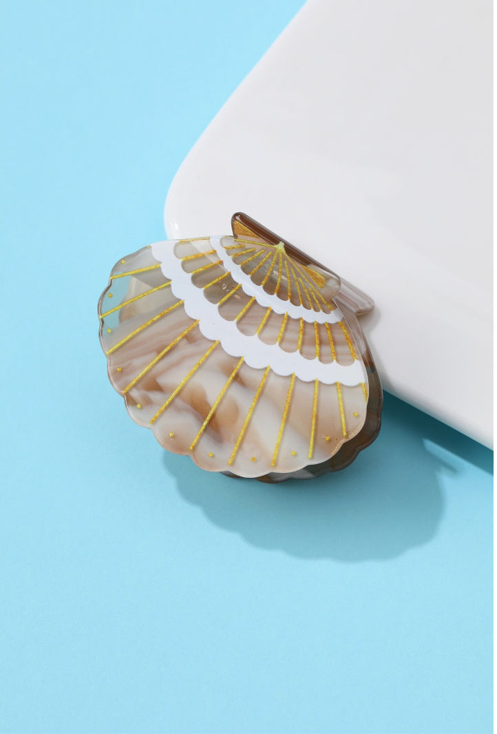 Brown marbled seashell-shaped acetate hair claw clip with gold ridged detailing