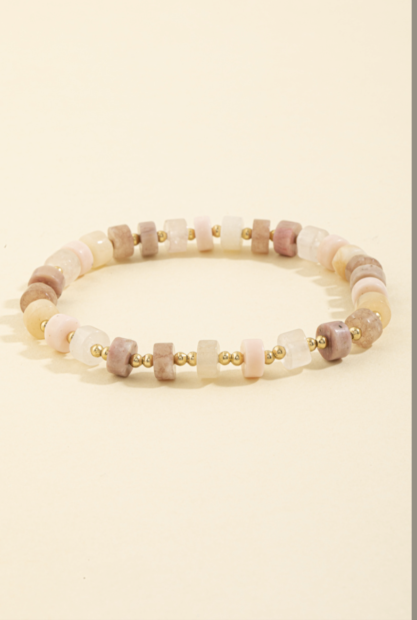 Stretch bracelet with pink, ivory, and taupe semi-precious stone beads accented by gold spacer beads.